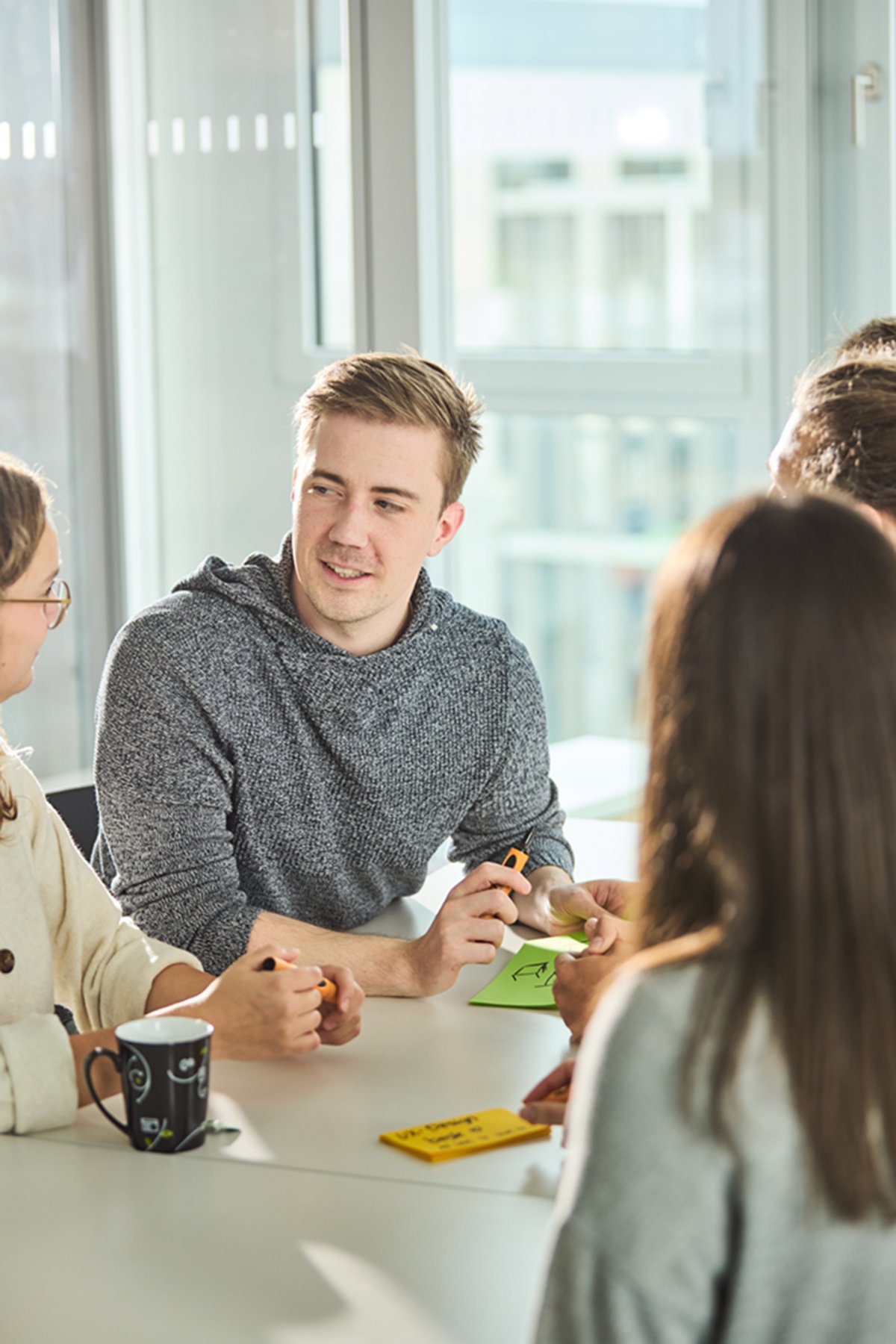 Ein lise-Team arbeitet gemeinsam mithilfe von Post-Its an einer App-Entwicklung