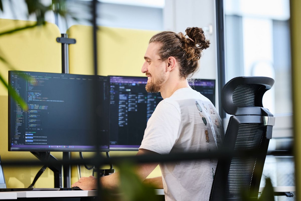 Ein lise-Entwickler mit einem Dutt nutzt auf dem Computer vor ihm Infrastructure as Code