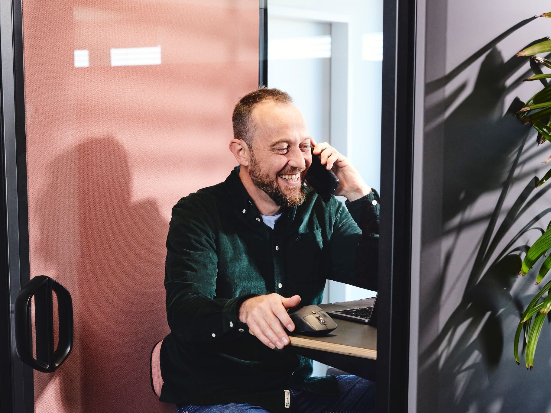 Einer der Geschäftsführer der lise führt ein Kundentelefonat in einer schalldichten Telefonzelle