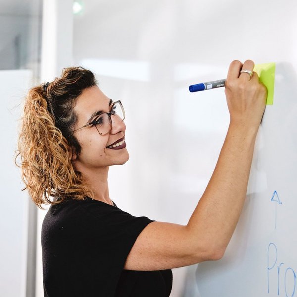 Eine lise-Mitarbeiterin dokumentiert die digitale Produktstrategie an einem Whiteboard