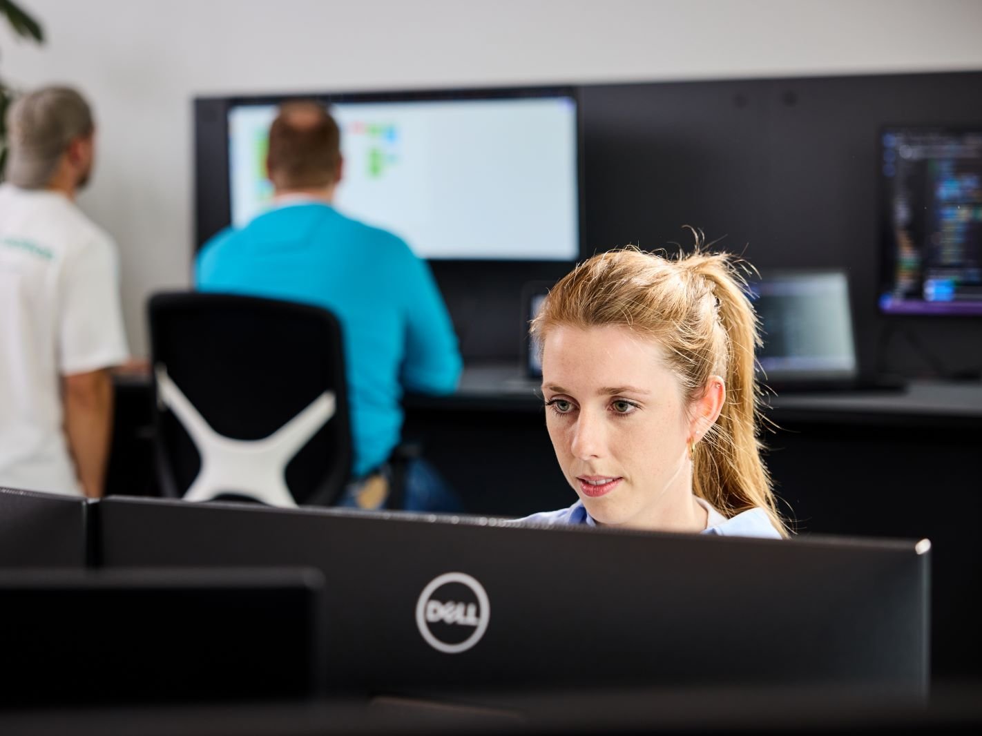 Eine lise-Entwicklerin arbeitet am Computer und auch im Hintergrund wird eine neue Software entwickelt