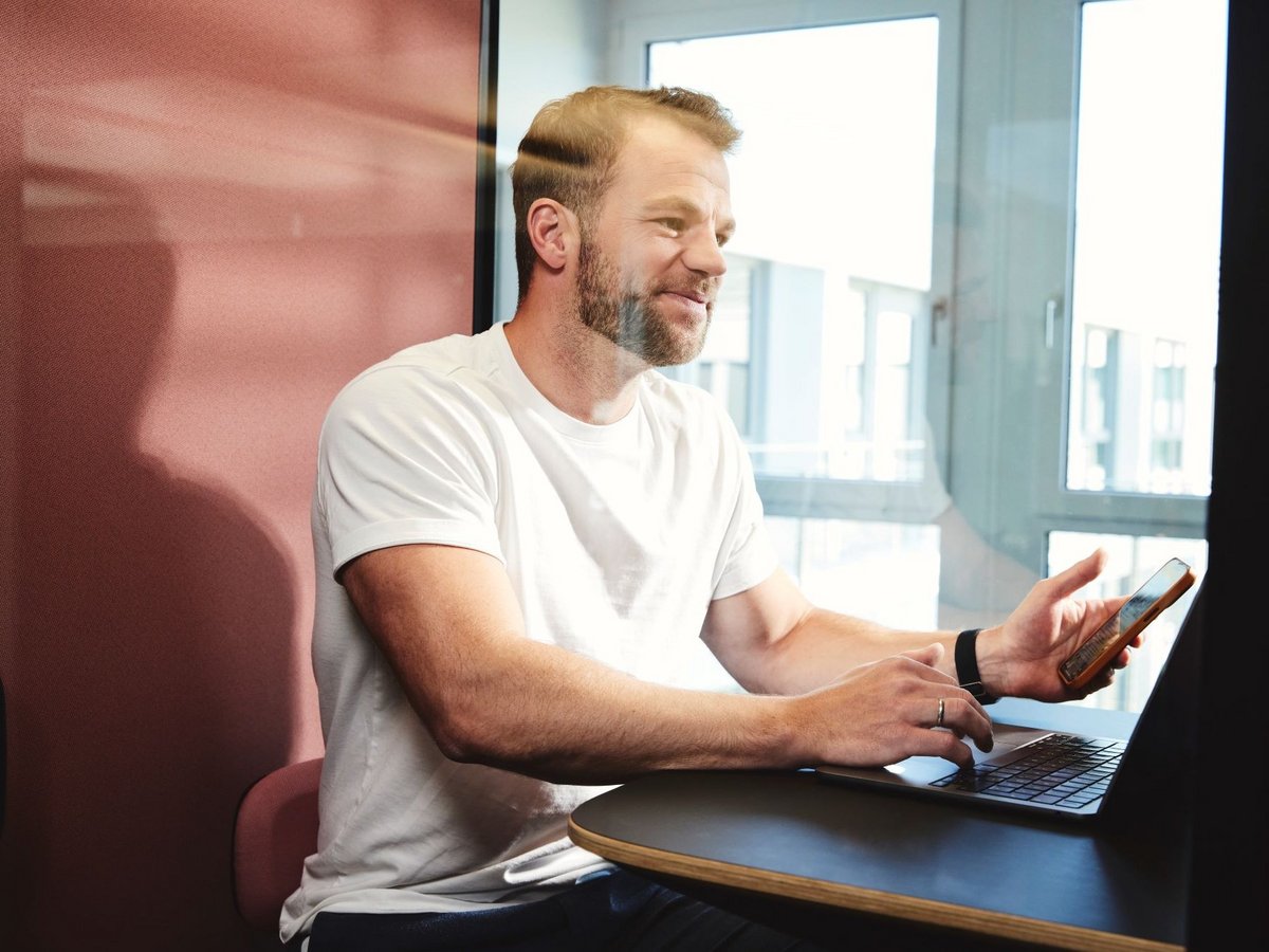 Ein lise-Entwickler führt ein Online-Telefonat in einer Telefonzelle in den lise-Räumlichkeiten