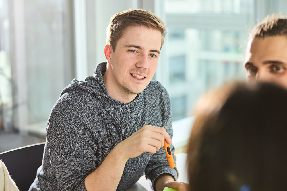 Ein lise-Mitarbeiter notiert in unserer Produktberatung Software-Ideen auf Post-Its
