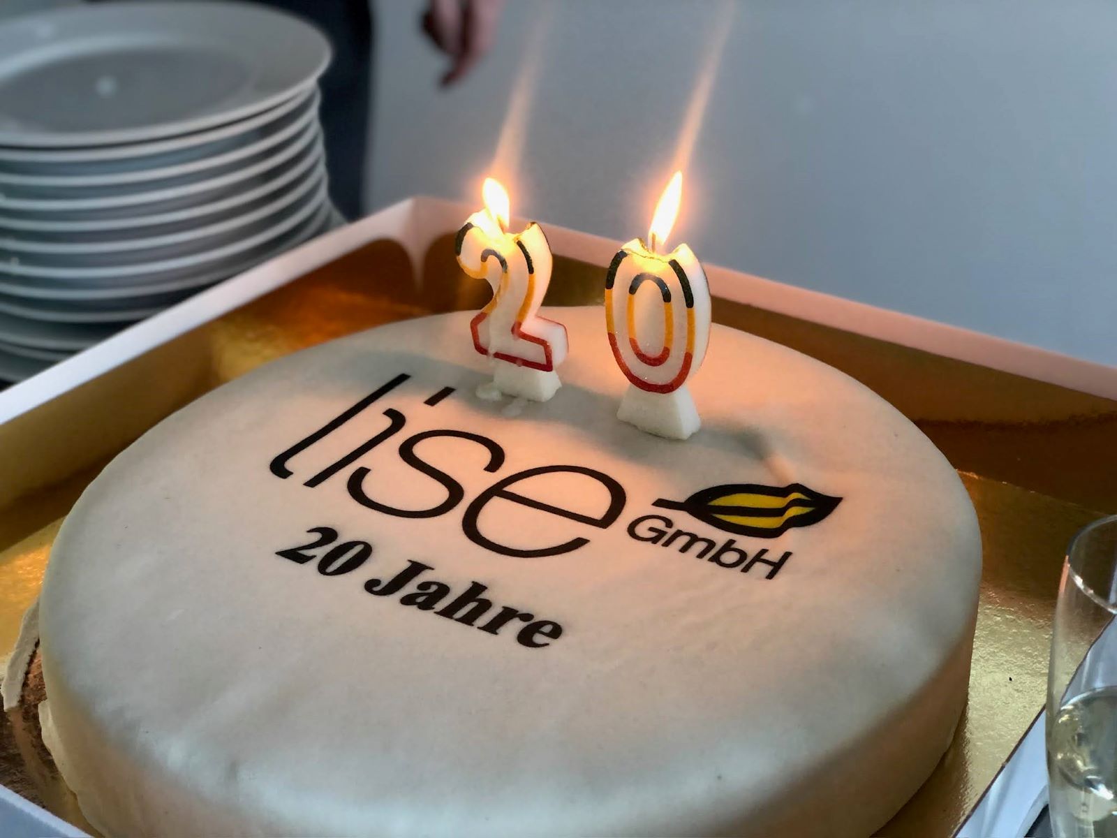 Ein Kuchen mit dem Schriftzug lise 20 Jahre und mit zwei Kerzen, die eine 20 darstellen